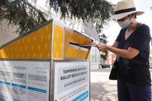 LOS ANGELES, CALIFORNIA - OCTOBER 05: A voter places their ballot in a mail-in ballot dropoff box outside of a library ahead of Election Day on October 5, 2020 in Los Angeles, California. Early voting has begun in California with Los Angeles County posting 400 secure vote-by-mail dropboxes across the county. (Photo by Mario Tama/Getty Images)