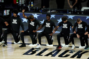 LAKE BUENA VISTA, FLORIDA - AUGUST 13:  Lance Thomas of the Brooklyn Nets gestures as he and teammates kneel in honor of the Black Lives Matter movement prior to an NBA basketball game against the Portland Trail Blazers at AdventHealth Arena at ESPN Wide World Of Sports Complex on August 13, 2020 in Lake Buena Vista, Florida. NOTE TO USER: User expressly acknowledges and agrees that, by downloading and or using this photograph, User is consenting to the terms and conditions of the Getty Images License Agreement.  (Photo by Ashley Landis-Pool/Getty Images)